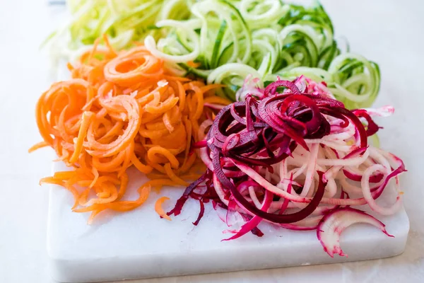 Sebze erişte havuç, kırmızı pancar, kabak ve salatalık mermer gemide spiralized. Organik gıda.