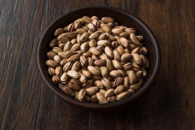 Ahşap kase içinde deniz hayvanı kabuğu ile fıstık fındık.