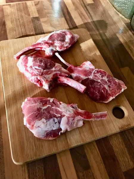 Raw Unfrozen Bloody Lamb Chops carne pe placă de lemn . — Fotografie, imagine de stoc