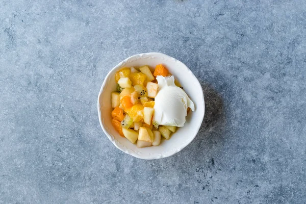 Salada de frutas com sorvete de baunilha em tigela de cerâmica . — Fotografia de Stock