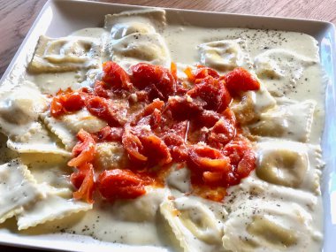 Domates, krem sos ve parmesan peyniri ile ravioli makarna.