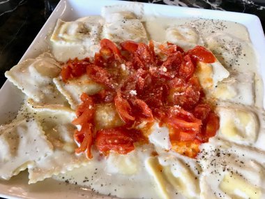 Domates, krem sos ve parmesan peyniri ile ravioli makarna.