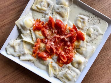 Domates, krem sos ve parmesan peyniri ile ravioli makarna.