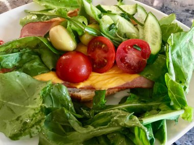 Pastırmalı Kruvasan Sandviç ve Çedar Peynirli Salata, Yeşil Zeytin, Salatalık ve Çeri Domates ile servis edilir