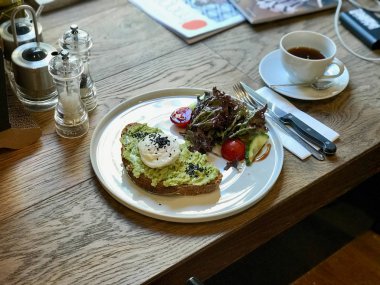 Ahşap Masa cafe dükkanında Kahve ile Haşlanmış Yumurta ile Avokado Yumurta Benedict