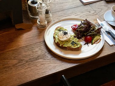 Ahşap Masa cafe dükkanında Kahve ile Haşlanmış Yumurta ile Avokado Yumurta Benedict