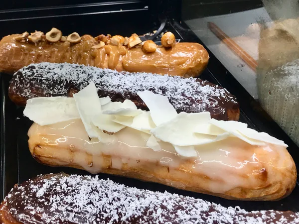 Эклеры французского десерта в витрине кафе — стоковое фото