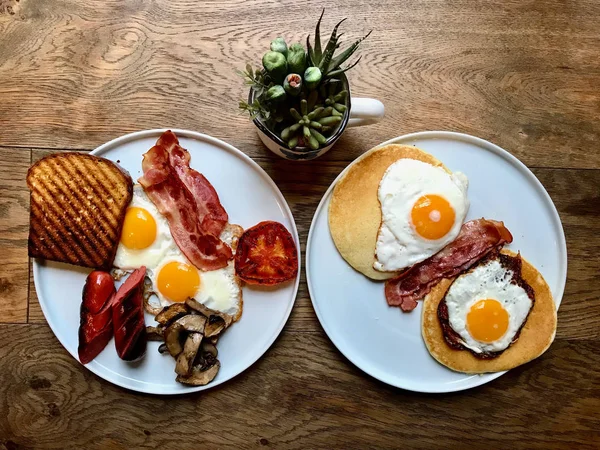Aussie / Australian Café da manhã com brinde Brioche, ovos fritos, salsicha de bacon crocante, panquecas salgadas e cogumelos . — Fotografia de Stock