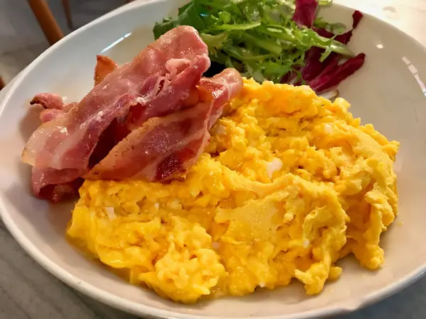 Ovos mexidos com bacon e salada para o café da manhã . — Fotografia de Stock