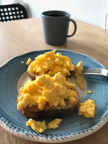 Rührei auf Toastbrot mit Kaffee zum Frühstück. — Stockfoto