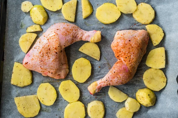 Rauwe twee gegrilde kippenpoten met aardappelen klaar om te koken. — Stockfoto