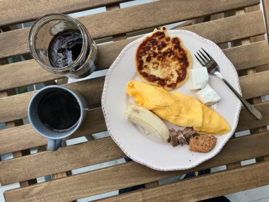 Ahşap Masada Fransız Omlet, Muz, Et, Kurabiye, Peynir ve Kahve ile Pancake Kahvaltı.