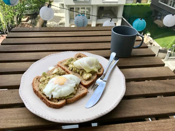 Pasta de tartina de aguacate machacada con huevos escalfados y pan tostado —  Fotos de Stock