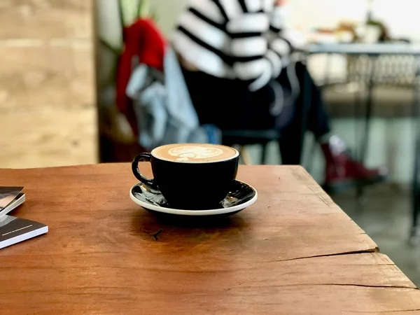 Плоский белый кофе Латте подается с Черный Кубок на деревянной поверхности — стоковое фото