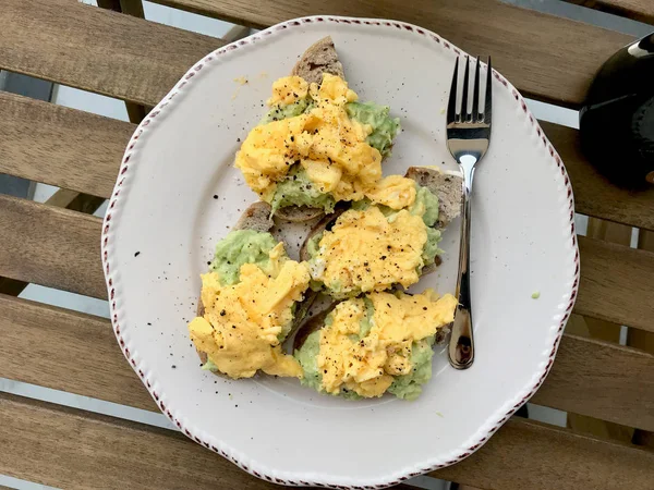 Huevos revueltos caseros con aguacate en pan tostado para el desayuno — Foto de Stock