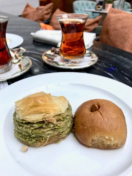 Türkisches Dessert sekerpare und Baklava mit Tee serviert in Teller im traditionellen Restaurant — Stockfoto