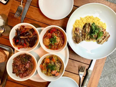 Restoranda Servis Edilen Ahşap Masa Üzerinde Kuskus ve Zeytinyağlı Tabaklar ile Limon Aromalı Tavuk Kalçaları.