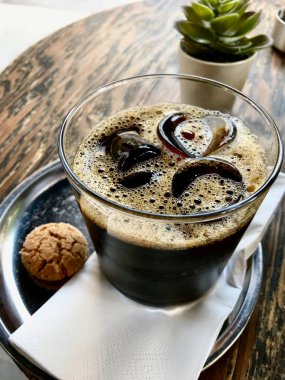 Cafe Shop buz ile soğuk Brew Kahve ahşap masa üzerinde çerez ile servis. 