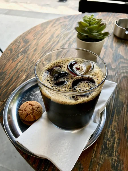 Cold Brew Coffee with Ice at Cafe Shop served with Cookie on Wooden Table. — Stock Photo, Image