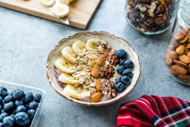 Yoğurt, Böğürtlen, Muz Dilimleri, Ceviz, Bal, Reçel, Yulaf, Badem, Susam ve Porselen Kase granola ile Acai Bowl.