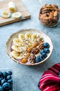 Yoğurt, Böğürtlen, Muz Dilimleri, Ceviz, Bal, Reçel, Yulaf, Badem, Susam ve Porselen Kase granola ile Acai Bowl.