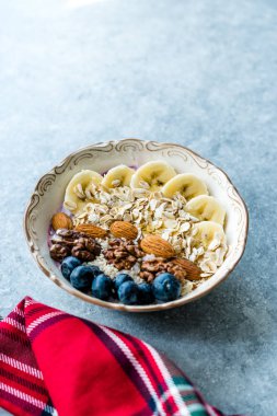 Yoğurt, Böğürtlen, Muz Dilimleri, Ceviz, Bal, Reçel, Yulaf, Badem, Susam ve Porselen Kase granola ile Acai Bowl.