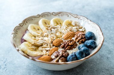 Yoğurt, Böğürtlen, Muz Dilimleri, Ceviz, Bal, Reçel, Yulaf, Badem, Susam ve Porselen Kase granola ile Acai Bowl.