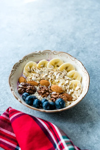 Yoğurt, Böğürtlen, Muz Dilimleri, Ceviz, Bal, Reçel, Yulaf, Badem, Susam ve Porselen Kase granola ile Acai Bowl.