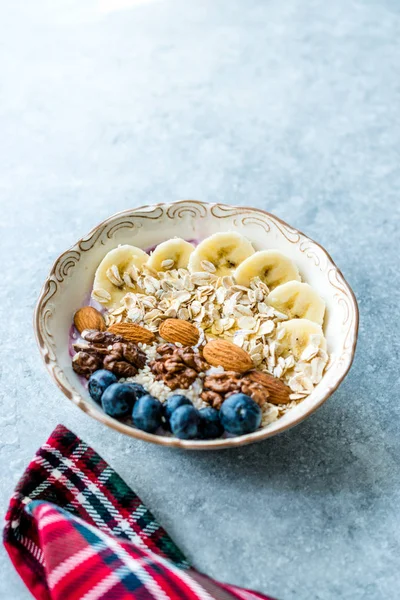 Yoğurt, Böğürtlen, Muz Dilimleri, Ceviz, Bal, Reçel, Yulaf, Badem, Susam ve Porselen Kase granola ile Acai Bowl.