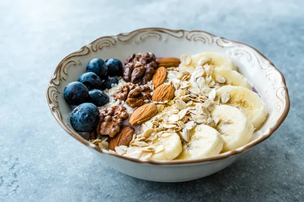 Acai Bowl with Yogurt, Blackberry, Banana Slices, Walnut, Honey, Jam, Oat, Almond, Sesame Seeds and Granola in Porcelain Bowl. — Stock Photo, Image