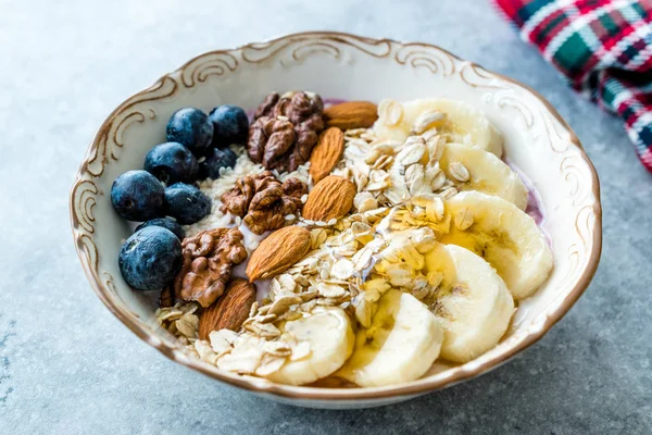 Yoğurt, Böğürtlen, Muz Dilimleri, Ceviz, Bal, Reçel, Yulaf, Badem, Susam ve Porselen Kase granola ile Acai Bowl.