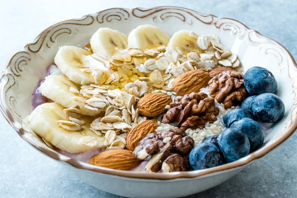 Yoğurt, Böğürtlen, Muz Dilimleri, Ceviz, Bal, Reçel, Yulaf, Badem, Susam ve Porselen Kase granola ile Acai Bowl.