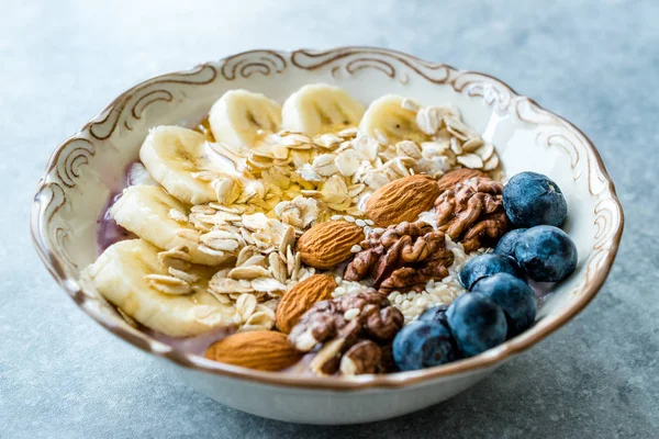 Yoğurt, Böğürtlen, Muz Dilimleri, Ceviz, Bal, Reçel, Yulaf, Badem, Susam ve Porselen Kase granola ile Acai Bowl.