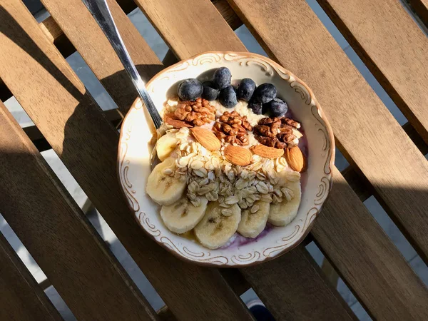 Yoğurt, Böğürtlen, Muz Dilimleri, Ceviz, Bal, Reçel, Yulaf, Badem, Susam ve Porselen Kase granola ile Acai Bowl.