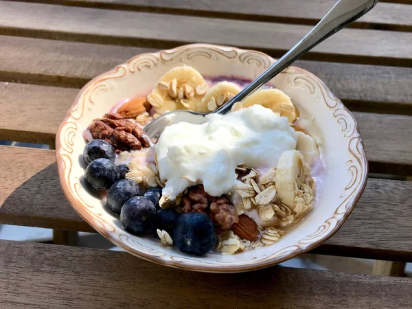 Acai Bowl with Yogurt, Blackberry, Banana Slices, Walnut, Honey, Jam, Oat, Almond, Sesame Seeds and Granola in Porcelain Bowl. — Stock Photo, Image