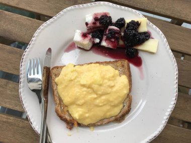 Tost Ekmeği, Peynir ve Böğürtlen Reçeli ile Kahvaltı Tabağında Ev Yapımı Kremalı Çırpılmış Yumurta. 