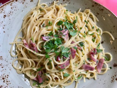 Spagetti Carbonara pastırma ve restoranda krem ile ile doğal ışık vurdu.