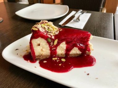 Restaurant'ta Antep Fıstığı Dilimleri ile Ahududu Cheesecake servis 