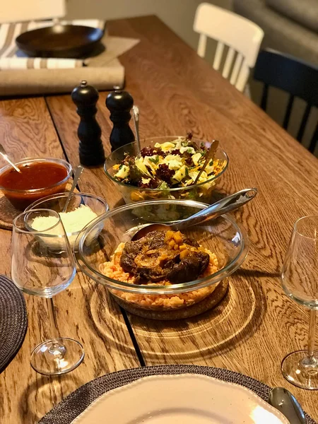 Osso Buco, Cañas de ternera que se cuecen en vino con Risotto de Azafrán, Pimienta Roja Asada y Romero en la Cena Mesa con Ensalada . — Foto de Stock