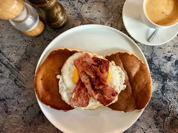 Panqueca salgada com ovos e bacon crocante para café da manhã salgado servido com café . — Fotografia de Stock