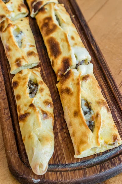 Traditionelle türkische Pide im Dönerrestaurant auf Holztisch. — Stockfoto