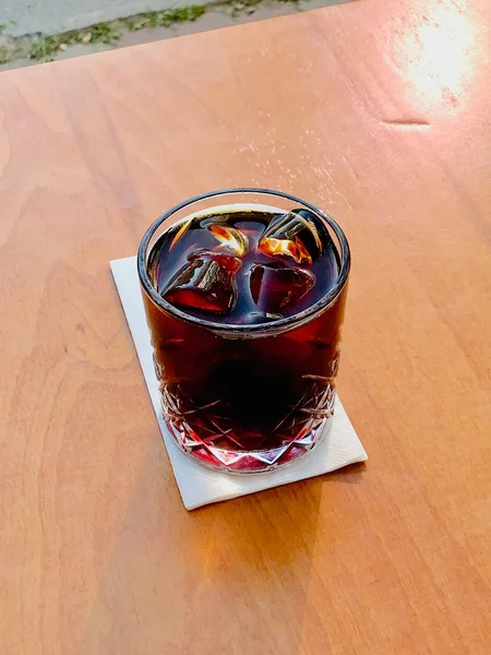 Koude brouwsel koffie met ijs of ijskoffie in Cafe Shop op houten oppervlak. — Stockfoto