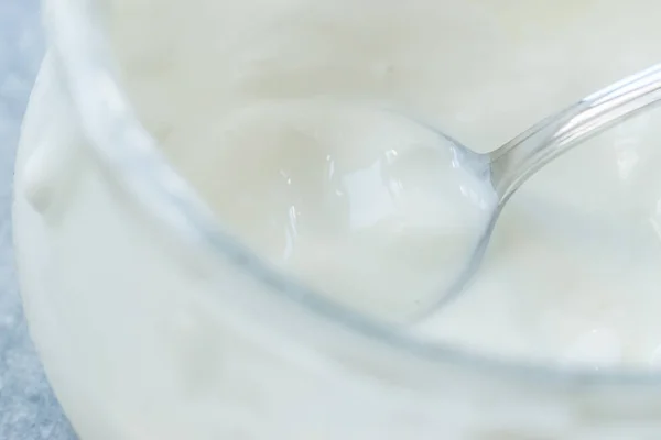 Yaourt de chèvre fait maison dans un bol en verre avec cuillère / crème pâtissière probiotique . — Photo