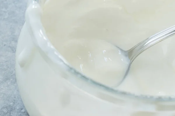 Домашнє йогурт кози в скляній мисці з ложкою/пробіотичних кремом. — стокове фото