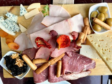 Kırmızı şarap ve çeşitli peynir tabağı, füme Beef, jambon, salam, meyve ile yeşil zeytin 