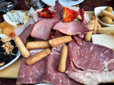 Kırmızı şarap ve çeşitli peynir tabağı, füme Beef, jambon, salam, meyve ile yeşil zeytin 