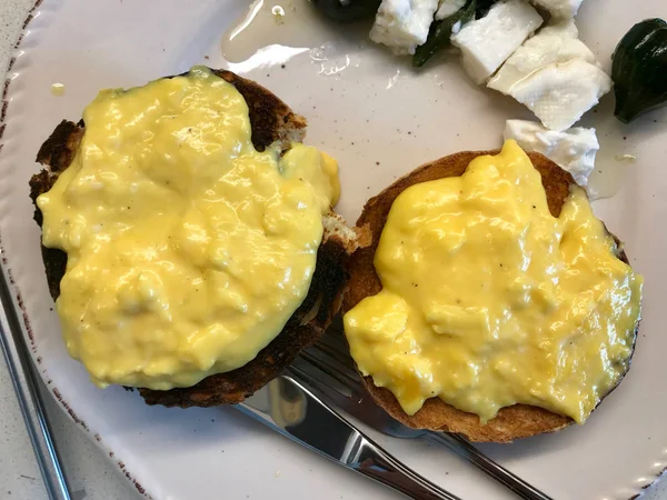 Uova strapazzate cremose fatte in casa sul pane Hamburger Bun nel piatto della colazione con formaggio e marmellata di fichi — Foto Stock