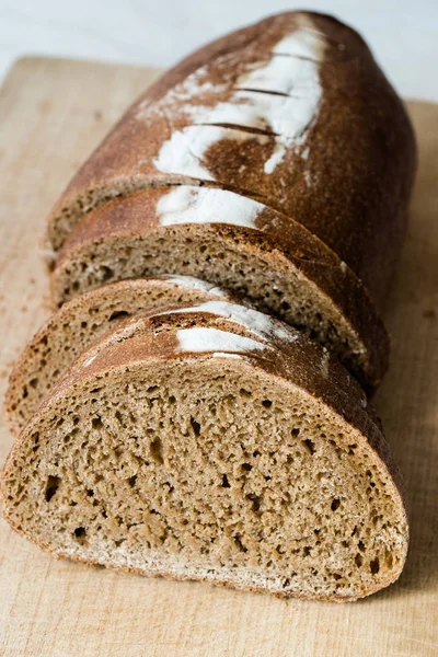 Einkorn tarwe brood met plakjes op houten plank. — Stockfoto