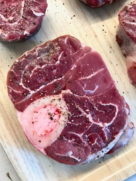 Ruwe vers gesneden kalfsvlees schacht en kruiderijen voor het maken van Osso Buco. — Stockfoto