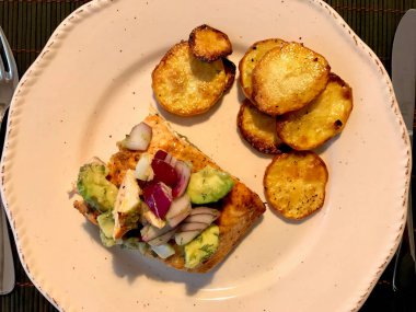 Avokado, Kırmızı Soğan ve Deniz Ürünleri Tabağında Fırında Yuvarlak Patates Dilimleri ile Somon Balık Fileto. 